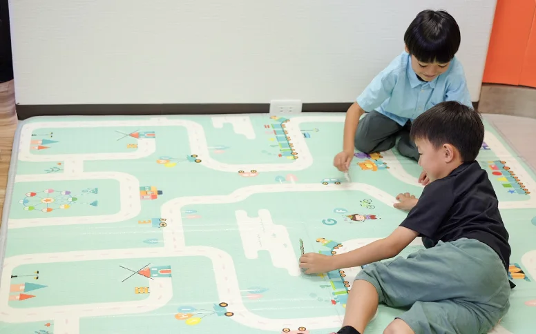 道路柄のプレイマットで遊ぶ男の子たち