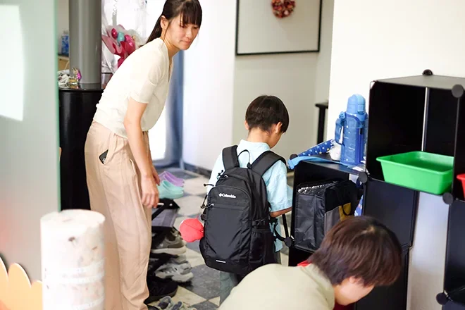 玄関で子どもに付き添うスタッフ
