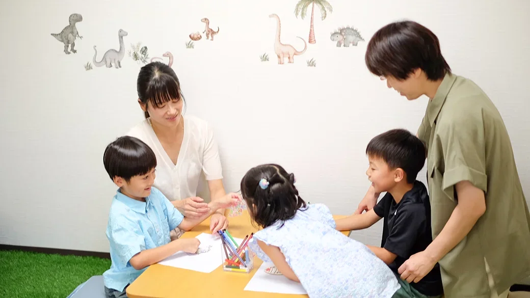 テーブルを囲んで過ごすスタッフと子どもたち